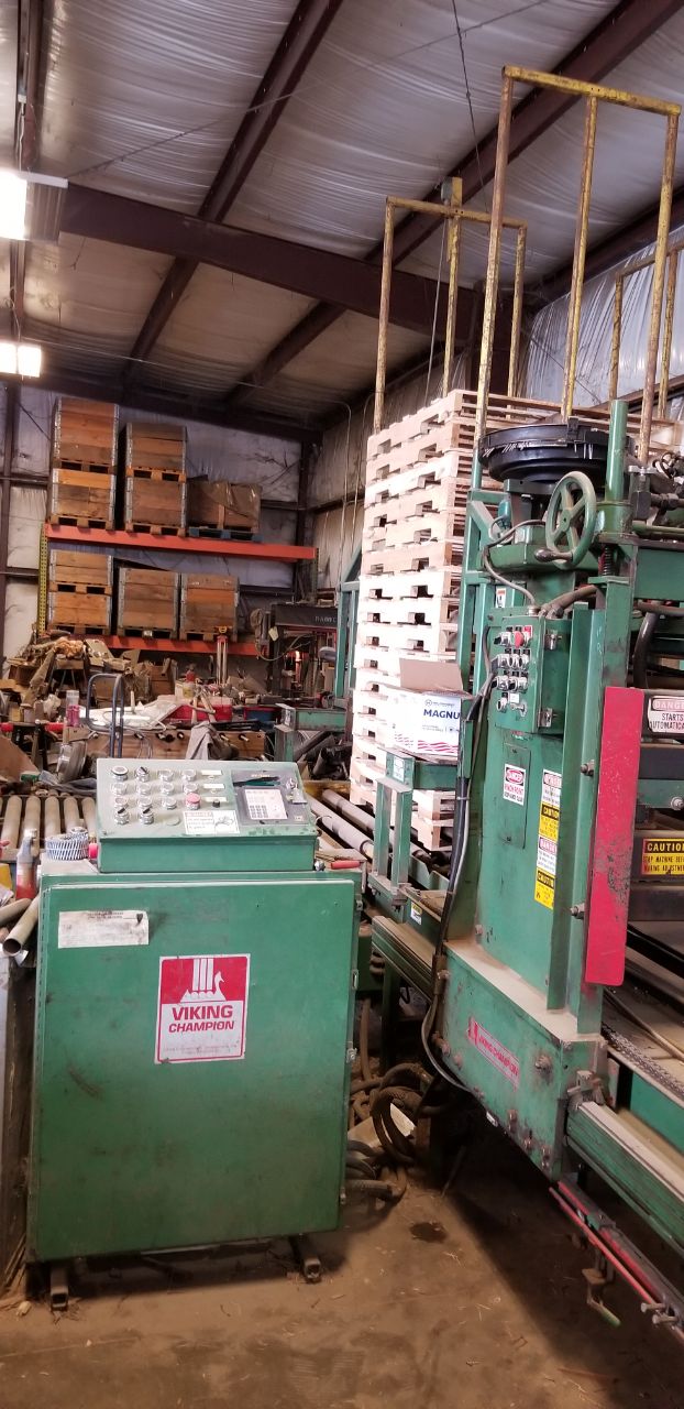 Pallet-making machinery and stacked wood products inside the workshop
